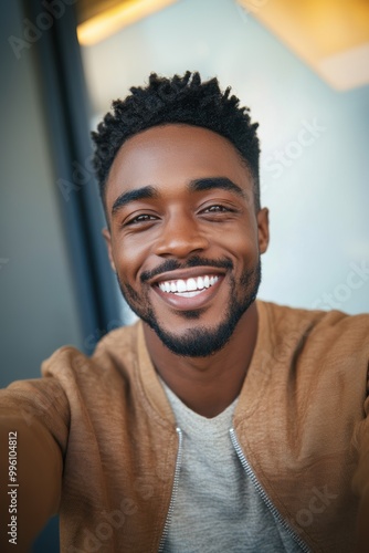 Happy young man smiling in casual outfit while taking a selfie