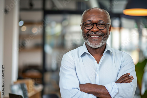 Smiling confident senior businessman standing in a modern office.