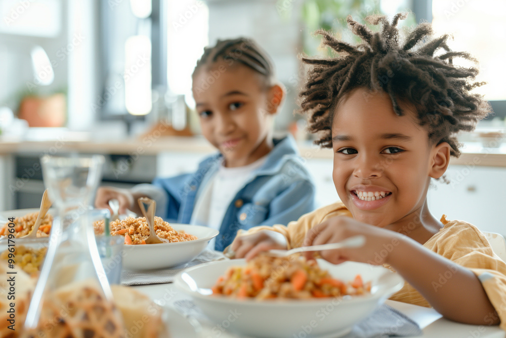 Two children are sitting at a table eating food Two children are sitting at a table eating food