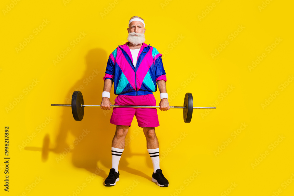 Full size photo poster of handsome granddad sportsman lift barbell wear trendy vintage sportswear isolated on yellow color background Full size photo poster of handsome granddad sportsman lift barbell wear trendy vintage sportswear isolated on yellow color background
