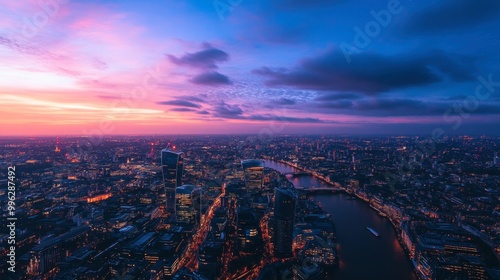 Aerial panorama of a large metropolis at twilight, with city lights starting to glow against the fading daylight.