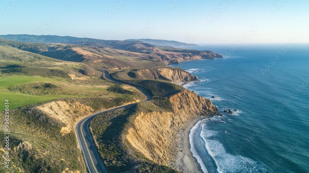 Aerial panorama of a winding coastal road with cliffs on one side and the ocean on the other, under a clear sky. Aerial panorama of a winding coastal road with cliffs on one side and the ocean on the other, under a clear sky.