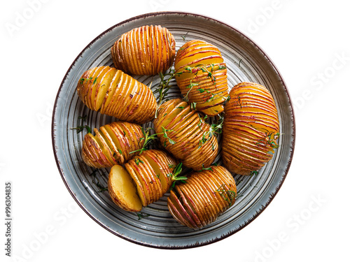 portion of Hasselback potatoes on plate above view isolated photo