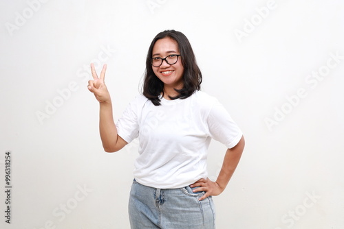 Smiling happy good-looking asian girl giving advice, showing two fingers as explain rules, make point, standing white background