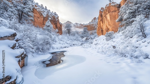 Wallpaper Mural A tranquil snowy valley with a frozen stream running through it, surrounded by snow-covered trees and rocky cliffs Torontodigital.ca