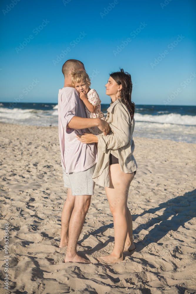 father mother and little daughter hug on beach. Happy Family father mother and little daughter hug on beach. Happy Family