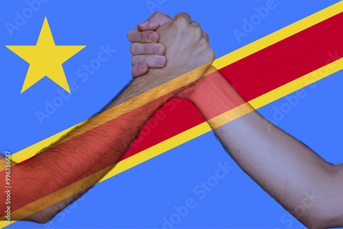 Two hands gathering front of Congo Democratic Republic flag, union of society, togetherness and  photo