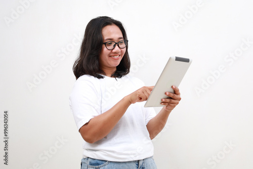 Smiling busy young asian business woman manager using tablet computer, happy business woman executive looking at tab device analyzing finance trading market data working standing over white background