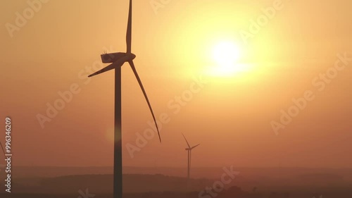 Farma wiatrowa na tle zachodzącego słońca, wiatrak, energia odnawialna