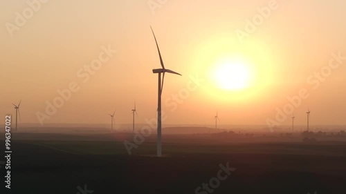 Farma wiatrowa na tle zachodzącego słońca, wiatrak, energia odnawialna