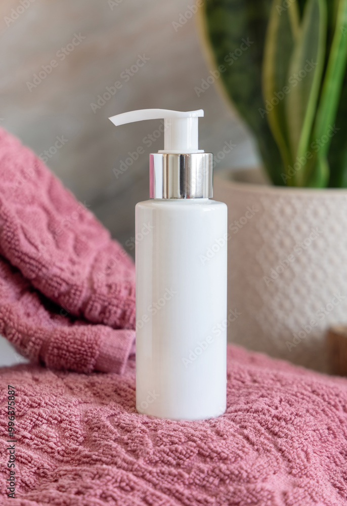 White cosmetic pump bottle on pink towels near green plant close up in bathroom, mockup White cosmetic pump bottle on pink towels near green plant close up in bathroom, mockup