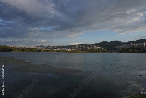 Grande parco di tirana al tramonto, vista su lago, alberi e montagne