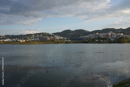 Grande parco di tirana al tramonto, vista su lago, alberi e montagne