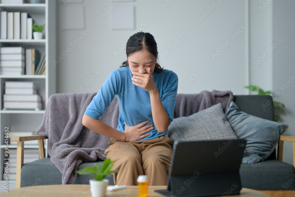 A woman sitting on a couch with a laptop in front of her A woman sitting on a couch with a laptop in front of her
