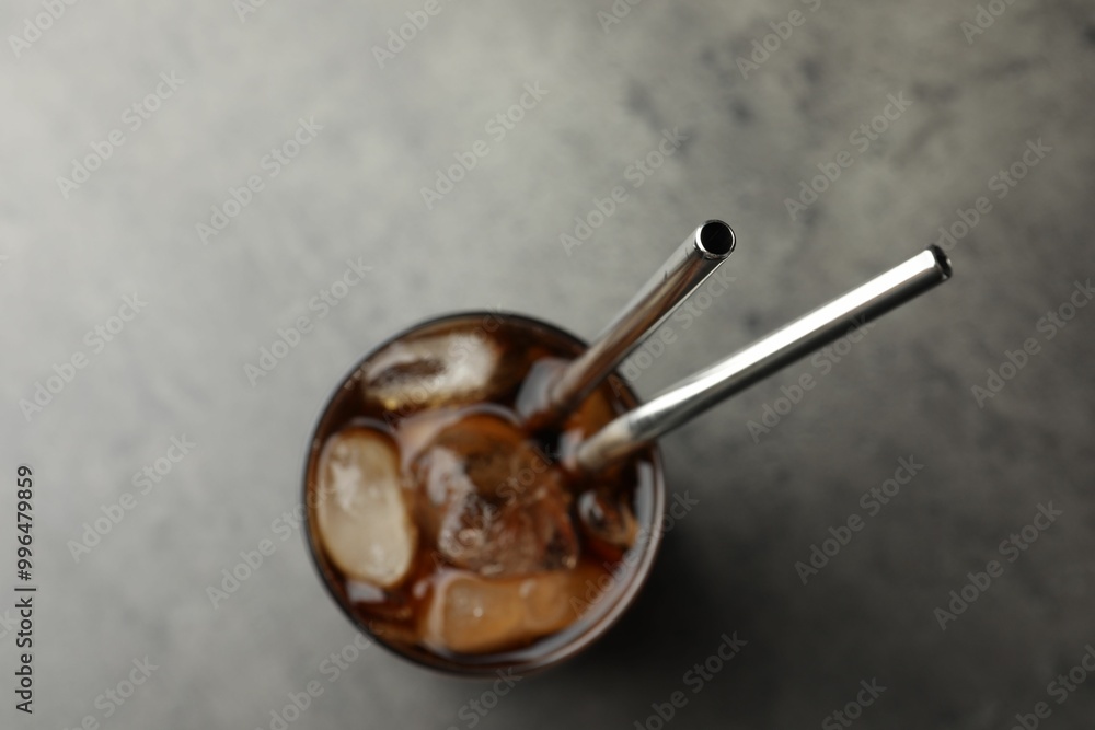 Fototapeta premium Tasty refreshing drink with straws in glass on grey table, top view