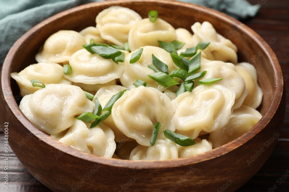 Delicious pelmeni with green onion in bowl on table, closeup Delicious pelmeni with green onion in bowl on table, closeup