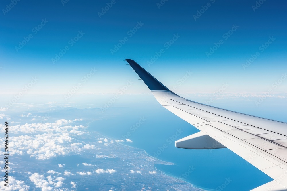 Fototapeta premium Airplane wing over clouds and blue sky, scenic view from window, travel experience.