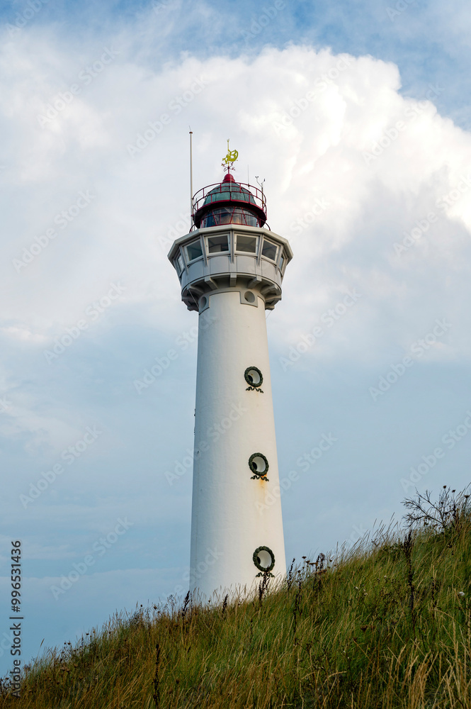 Lighthouse in the dunes of the Dutch town of Egmond aan Zee with clouds Lighthouse in the dunes of the Dutch town of Egmond aan Zee with clouds