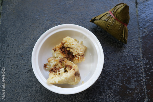 Bacang or bakcang. Chinese savoury sticky rice dumplings in bamboo leaves wrapping.  It contains meat inside the taste very delicious. photo