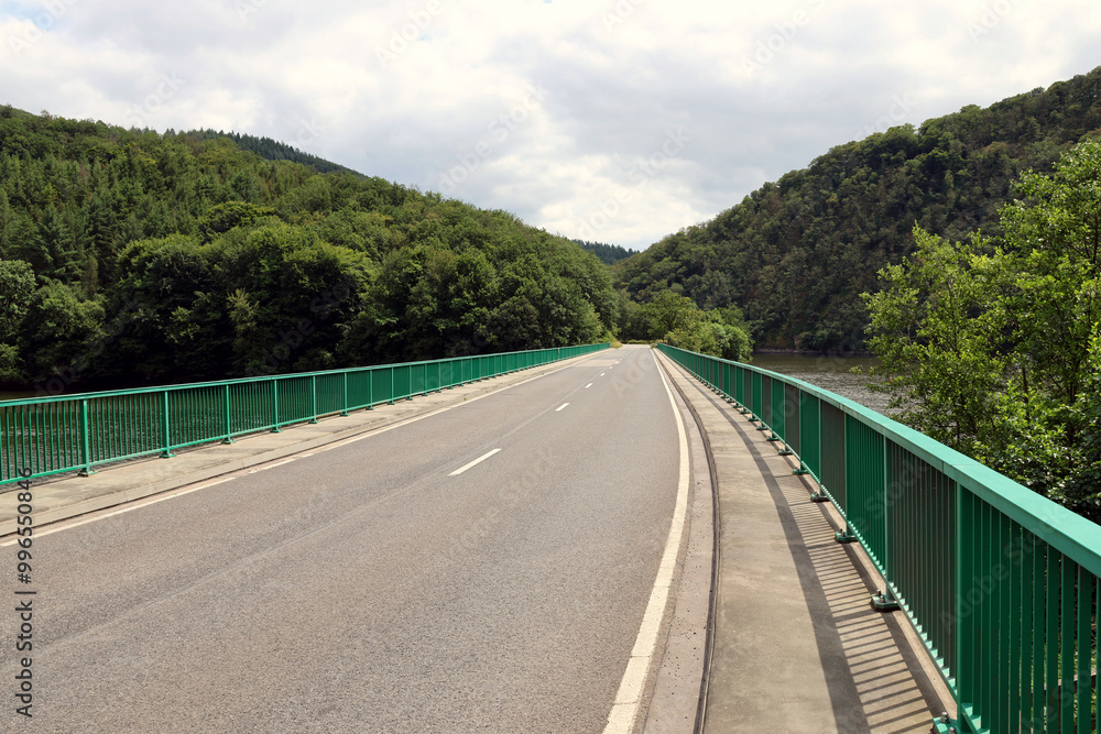 Brücke der Straße N10 über den Fluss Our in Höhe der Ourtalsperre zwischen Vianden und Bivels in Luxemburg. Aussicht vom Premium-Wanderweg Nat'Our Route 5. Brücke der Straße N10 über den Fluss Our in Höhe der Ourtalsperre zwischen Vianden und Bivels in Luxemburg. Aussicht vom Premium-Wanderweg Nat'Our Route 5.
