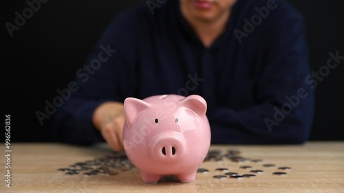 Man put coins into piggy bank, Saving money and Investment concept.