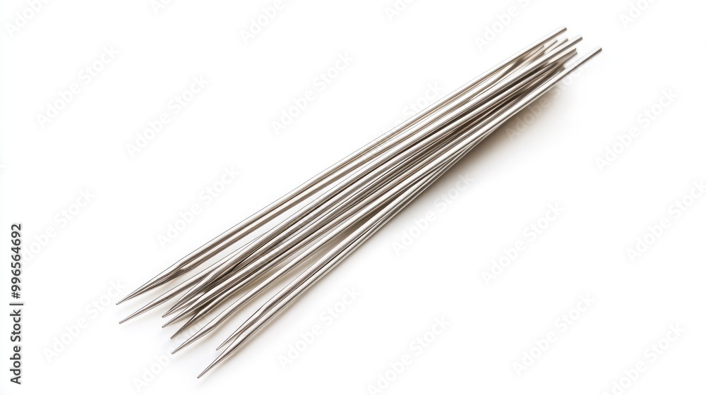 A set of metallic sewing needles arranged neatly on a white surface, perfect for sewing, crafting, or DIY projects. A set of metallic sewing needles arranged neatly on a white surface, perfect for sewing, crafting, or DIY projects.