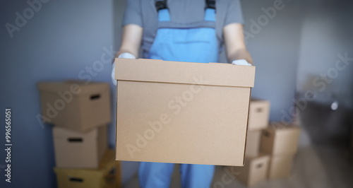 Obraz na płótnie Close-up of worker loading cardboard boxes with owners belongings to new apartment. Guy from delivery service help with relocation. Loader, moving concept w salonie