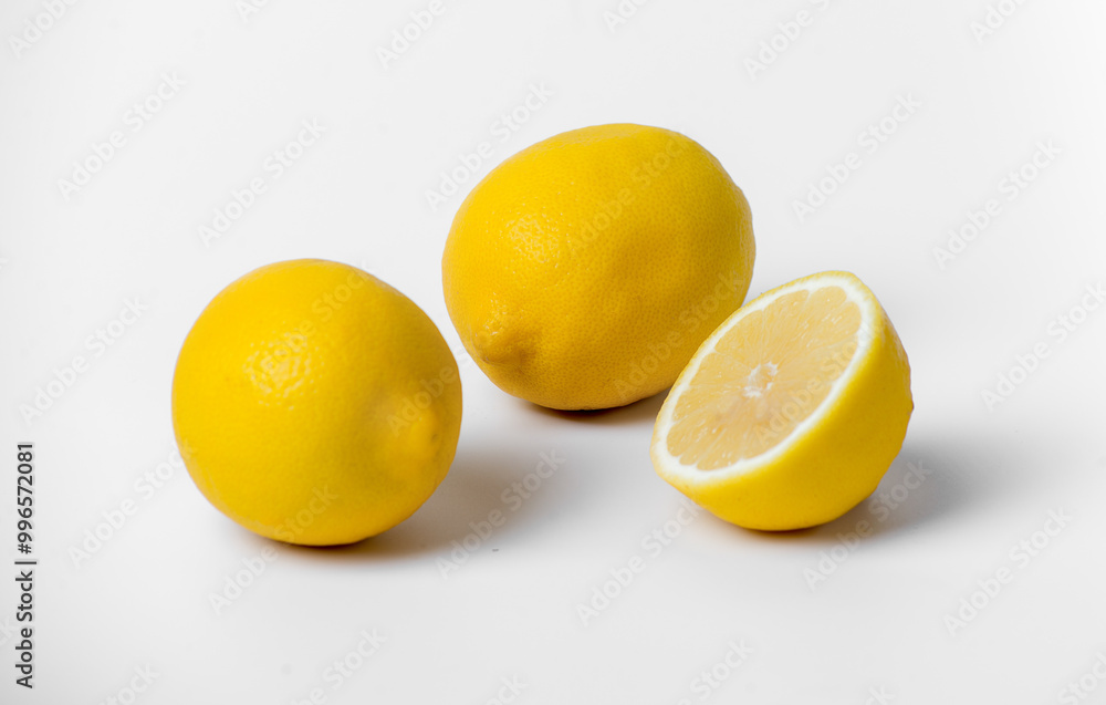 Three lemons are sitting on a white background. They are all yellow and appear to be fresh Three lemons are sitting on a white background. They are all yellow and appear to be fresh