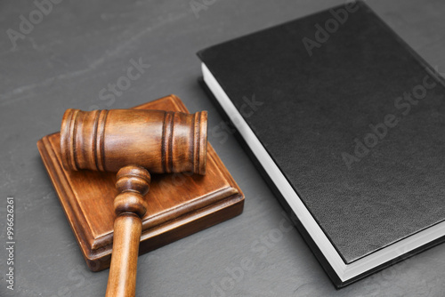 Book and judge's gavel on gray textured table