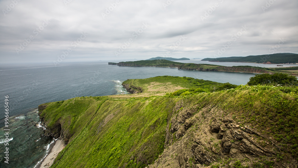 A breathtaking view of a steep cliff that overlooks a vast body of water A breathtaking view of a steep cliff that overlooks a vast body of water
