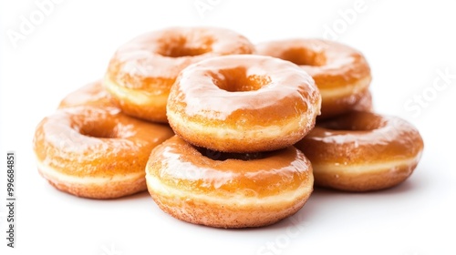 A collection of glazed cinnamon donuts stacked together against a white background