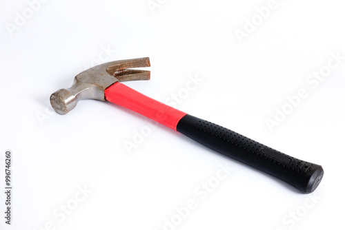 Close up medium sized hammer that has two functions as a nail pick and nail hammer, with a handle covered in black and red rubber isolated on a white background. Little bit rusty