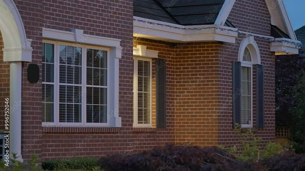 Establishing shot of two story stucco luxury house with garage door, big tree and nice landscape at night in Vancouver, Canada, North America. Night time on June 2024. ProRes 422 HQ.