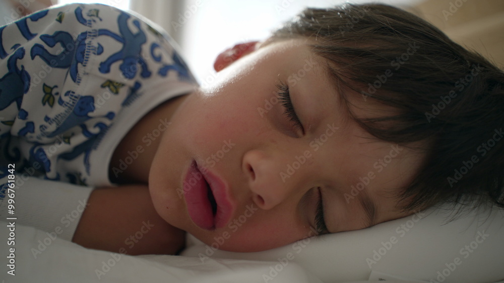 Child waking up reluctantly, eyes open but wishing to go back to sleep on a white pillow, capturing a peaceful morning moment Child waking up reluctantly, eyes open but wishing to go back to sleep on a white pillow, capturing a peaceful morning moment