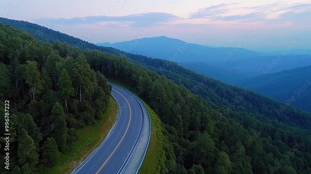 Experience the serenity of a winding road nestled in a dense forest, with vibrant green vegetation and majestic mountains stretching into the distance Experience the serenity of a winding road nestled in a dense forest, with vibrant green vegetation and majestic mountains stretching into the distance