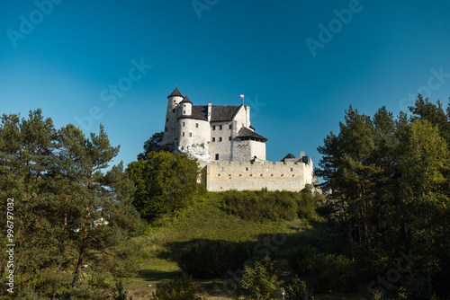 Bobolice Royal Castle at Sunset, Surrounded by dark green Forest and Hills Stunning Medieval Fortress in Poland’s Countryside, Ideal for travel, architecture, and historical content. High quality