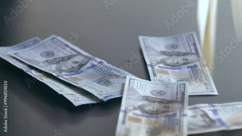 The man picks up a stack of banknotes