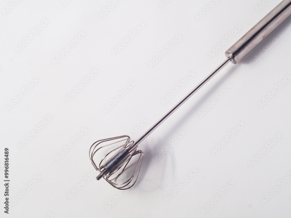 Manual mixer with spring, made of stainless steel on a white background, pressing the handle causes the tip of the tool to rotate as a mixer Manual mixer with spring, made of stainless steel on a white background, pressing the handle causes the tip of the tool to rotate as a mixer