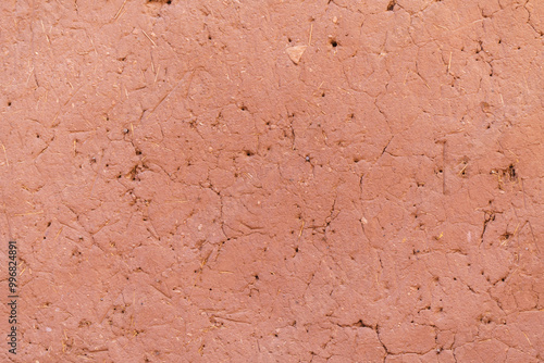 Red clay textured wall, cracked and aged ancient building.