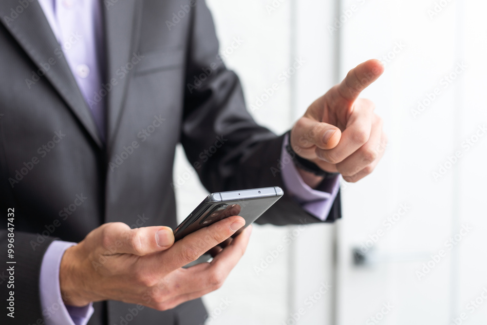 Businessman in the suit is using smartphone Businessman in the suit is using smartphone