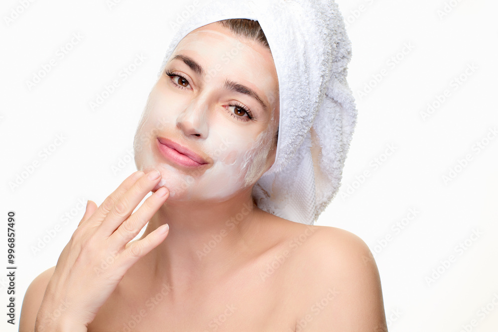 Woman enjoying skincare routine with facial mask and towel Woman enjoying skincare routine with facial mask and towel