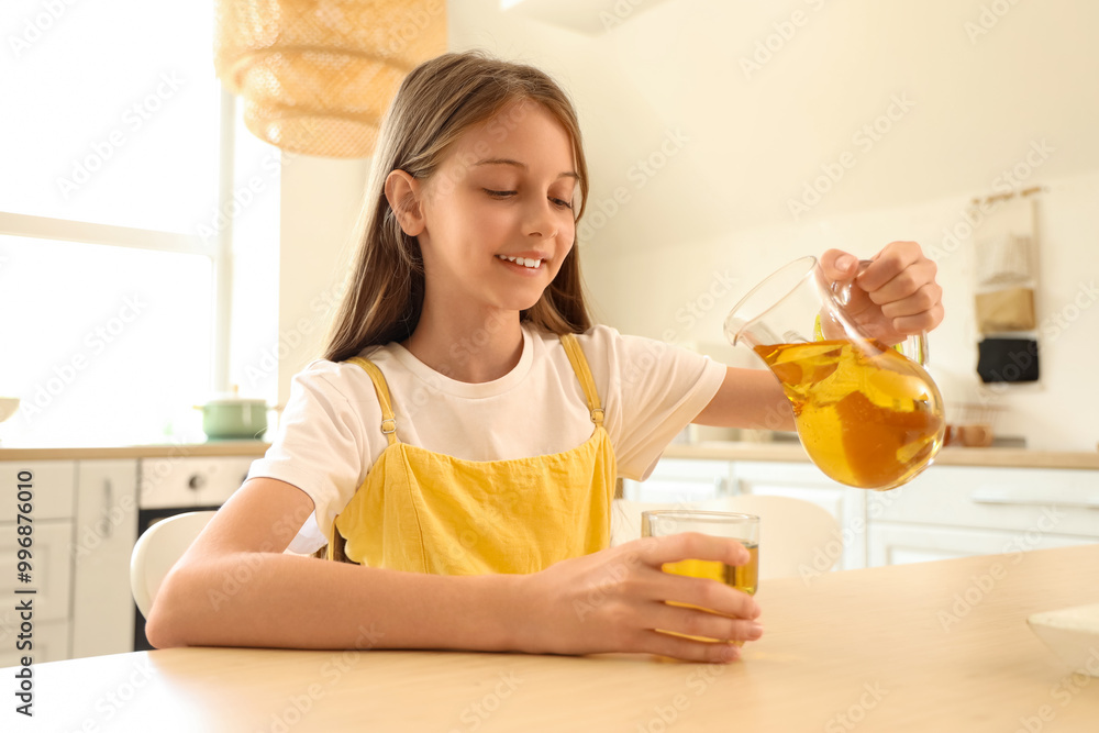 Little girl pouring apple juice into glass in kitchen Little girl pouring apple juice into glass in kitchen