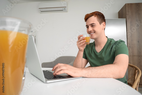 Young man with laptop drink...