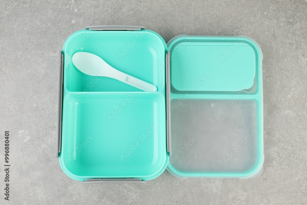 Empty plastic lunch box with cutlery on light grey table, top view