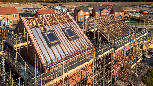 Aerial view of a roof under construction with attic room and skylight window on a new build housing development