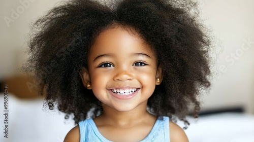 Smiling Little Girl with Big Curly Hair and Bright Dress Indoors 