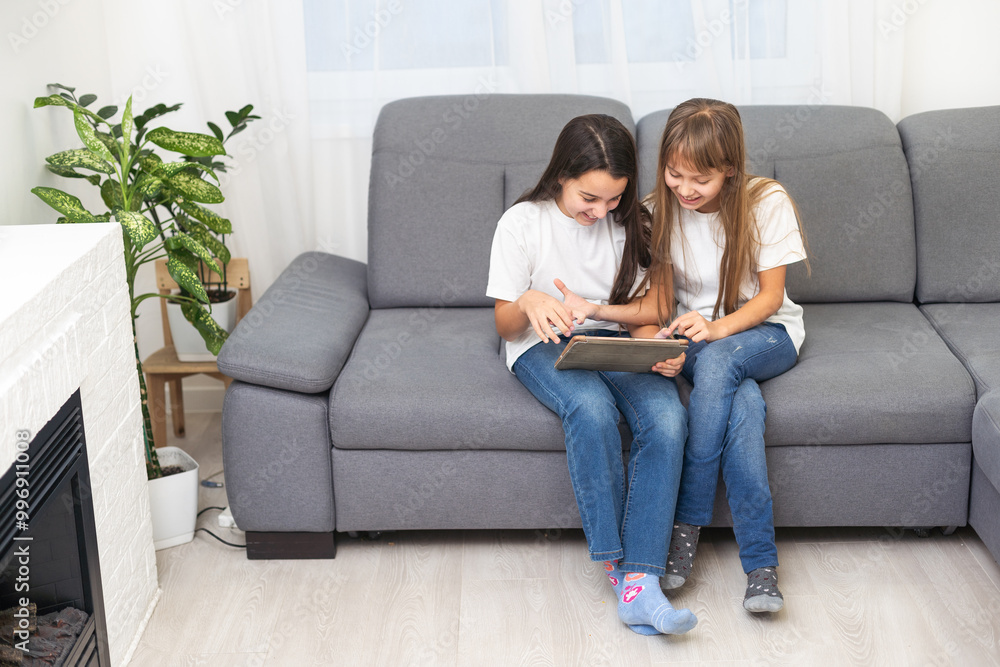 Beautiful cute little girl with tablet playing together smiling and having fun on the couch at home. Happy family, digital technology, life style concept. Beautiful cute little girl with tablet playing together smiling and having fun on the couch at home. Happy family, digital technology, life style concept.