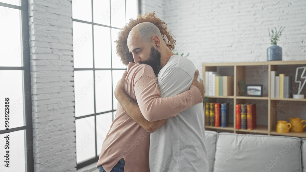 Fototapeta premium Two men embracing in a loving hug inside a cozy living room with modern decor, expressing friendship or relationship.