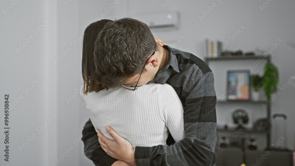 A man and woman embrace lovingly in a cozy living room, evoking a sense of comfort, relationship, and togetherness. A man and woman embrace lovingly in a cozy living room, evoking a sense of comfort, relationship, and togetherness.