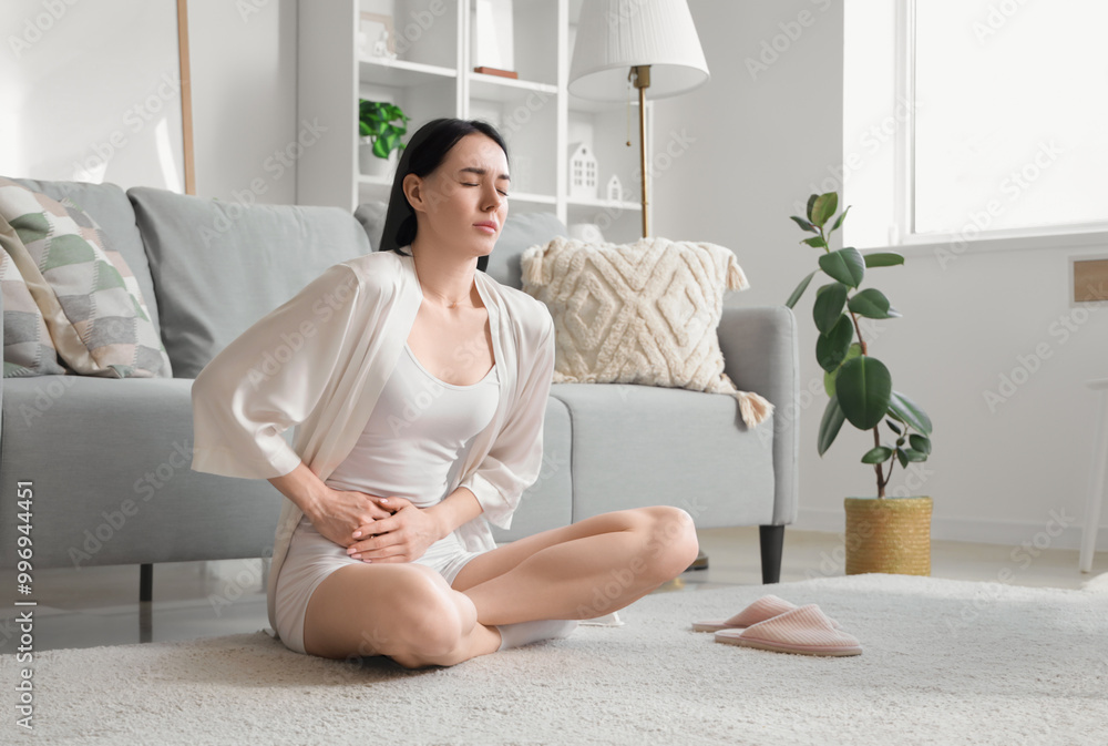 Young woman suffering from severe abdominal pain at home Young woman suffering from severe abdominal pain at home